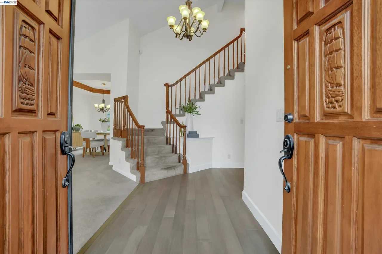 Double wood doors open to a bright foyer and curved staircase at 19475 Mount Jasper Drive.
