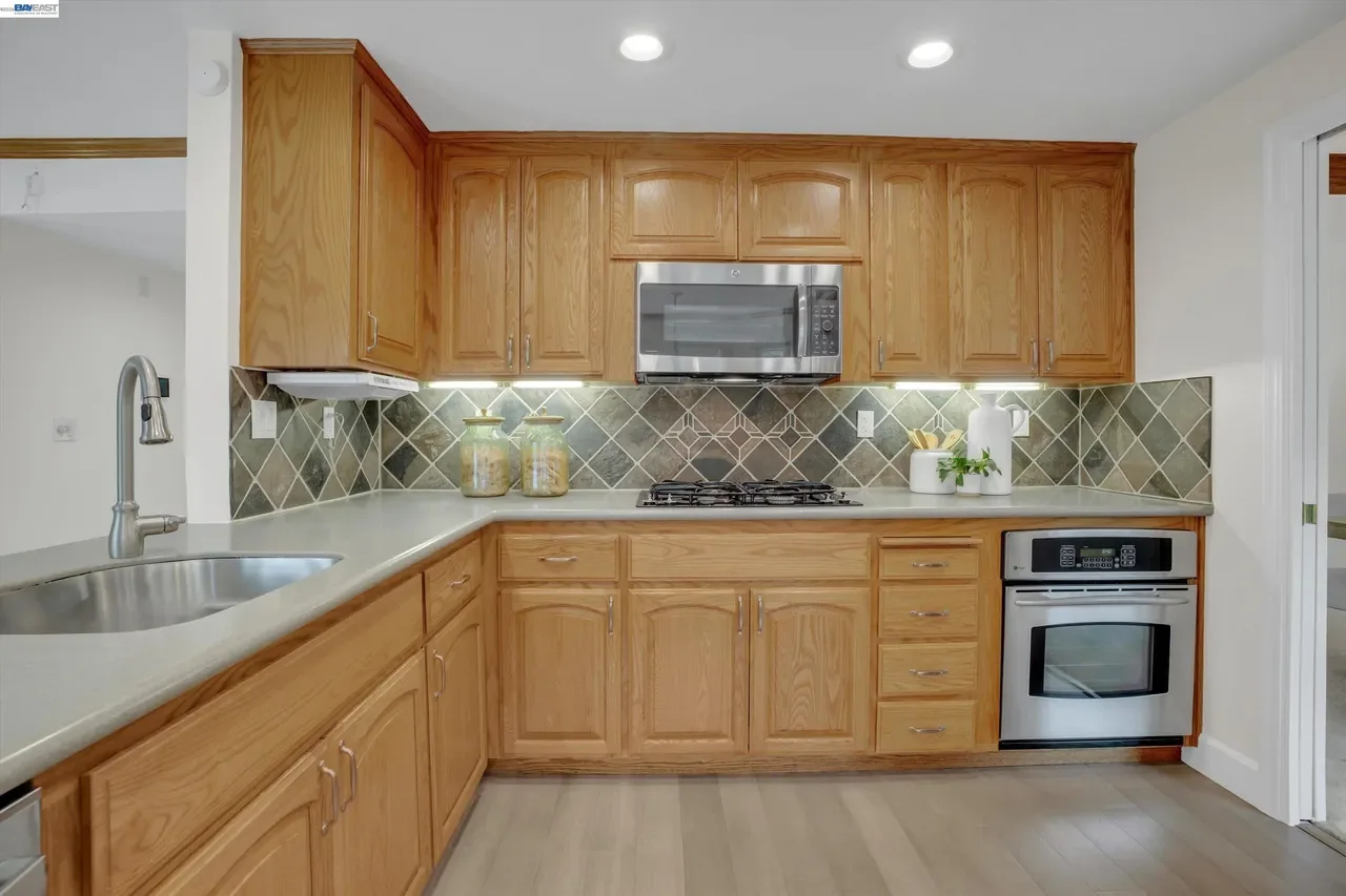 Wood cabinetry wraps the kitchen beneath recessed lighting and a tile backsplash at 19475 Mount Jasper Drive.