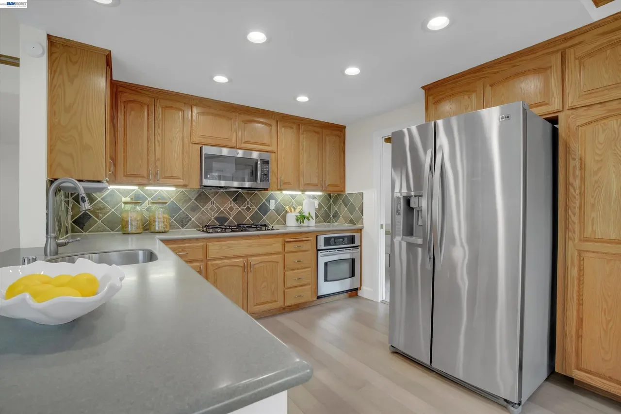 The stainless refrigerator and peninsula complete the kitchen’s efficient work zone at 19475 Mount Jasper Drive.