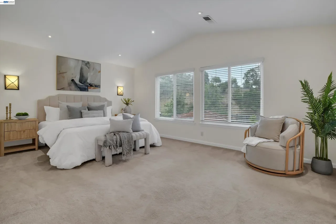 The spacious primary bedroom is brightened by a wide bank of windows at 19475 Mount Jasper Drive.