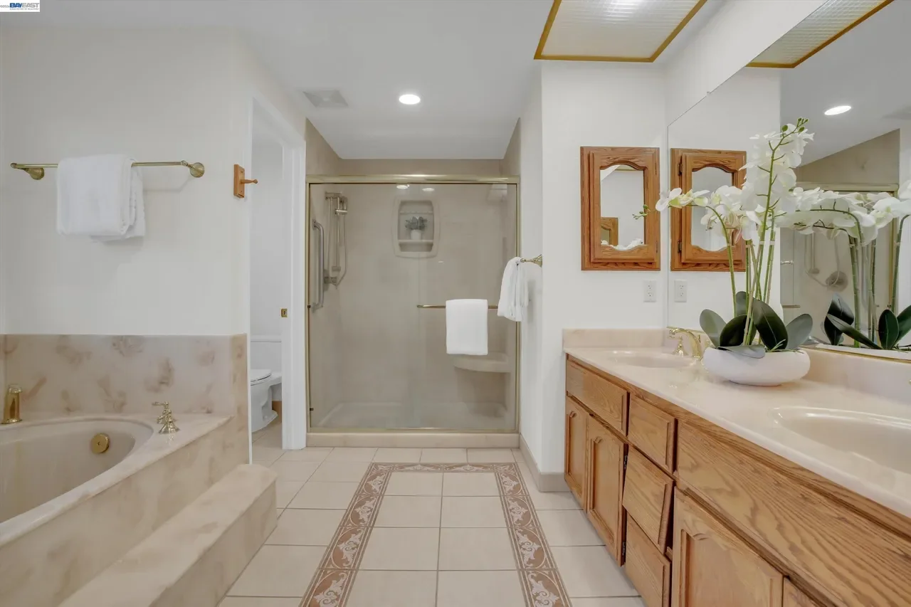 The primary bath combines a dual vanity, jetted soaking tub, and separate shower at 19475 Mount Jasper Drive.