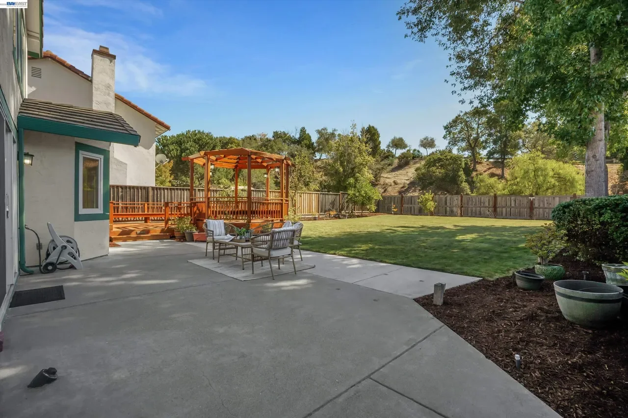 The rear patio opens to an oversized lawn, gazebo, and mature landscaping at 19475 Mount Jasper Drive.
